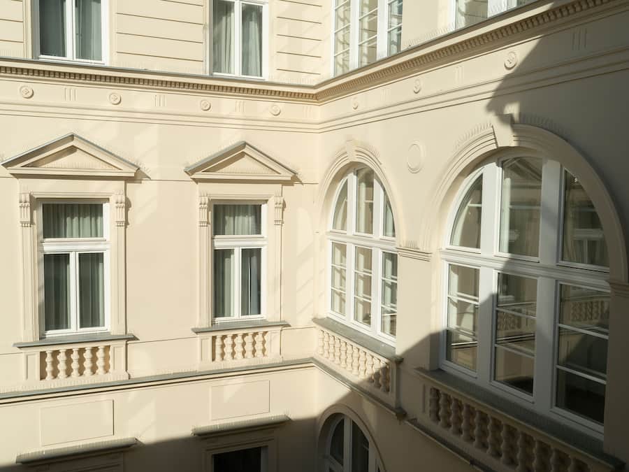 A building with multiple windows, including arched and rectangular designs, and decorative moldings.