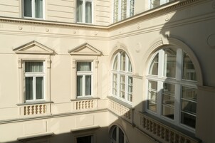 A building with multiple windows, including arched and rectangular designs, and decorative moldings.