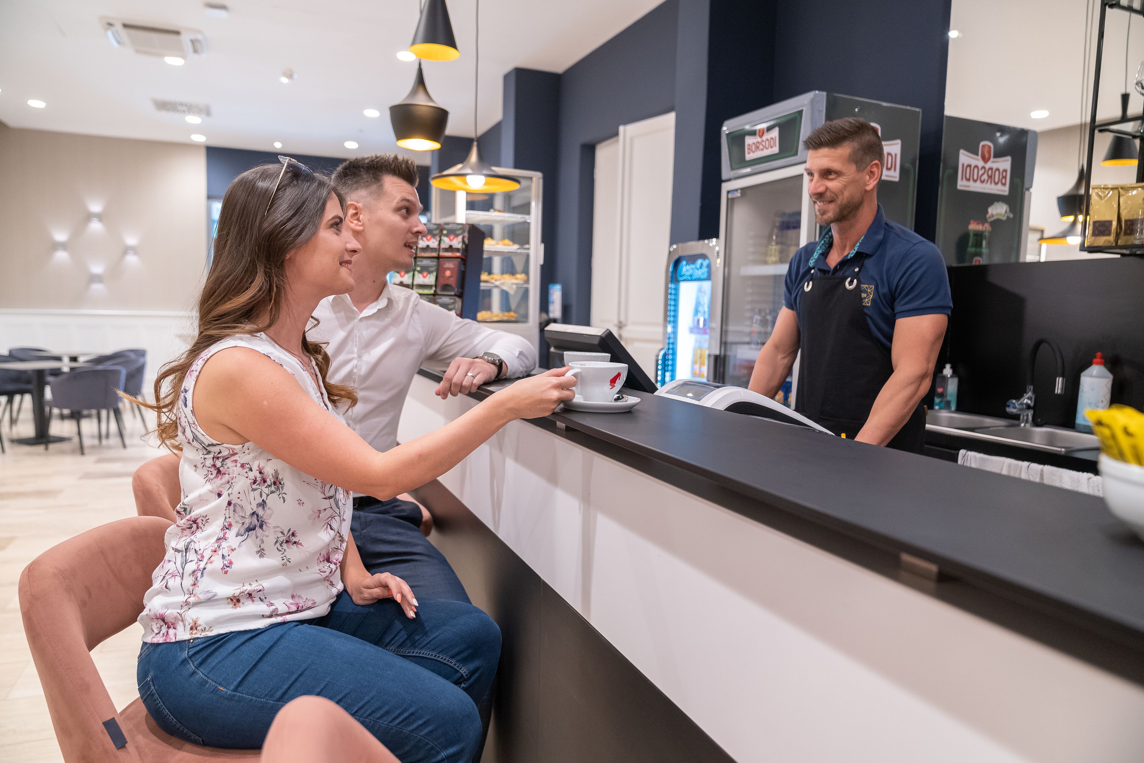 Un espace d’accueil comprenant un comptoir, une machine à café et un réfrigérateur.