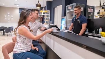 Un espace d’accueil comprenant un comptoir, une machine à café et un réfrigérateur.