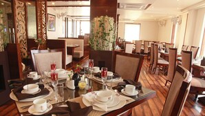 Un restaurante con mesas de madera dispuestas para comer, incluyendo platos, vasos y cubiertos.