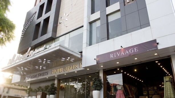Fachada de hotel con señalización que indica 'Hotel Ajemer' y 'Rivage'.