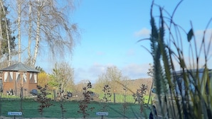 A view from inside a vehicle, looking out through a window at a gravel driveway leading to a house with a fenced yard. There are two signs indicating 'Wohnung 2' and 'Wohnung 4'. - Guesthouse Buberl, near Legoland and Skylinepark (Krumbach (Schwaben))