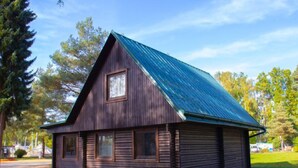 A wooden cabin with a sloped roof and a window.