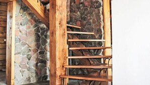Una escalera de madera con un fondo de pared de piedra.