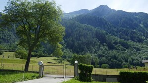 A gated entrance to a property with a mountain backdrop. - Vacation home Terry by Interhome (Olivone)