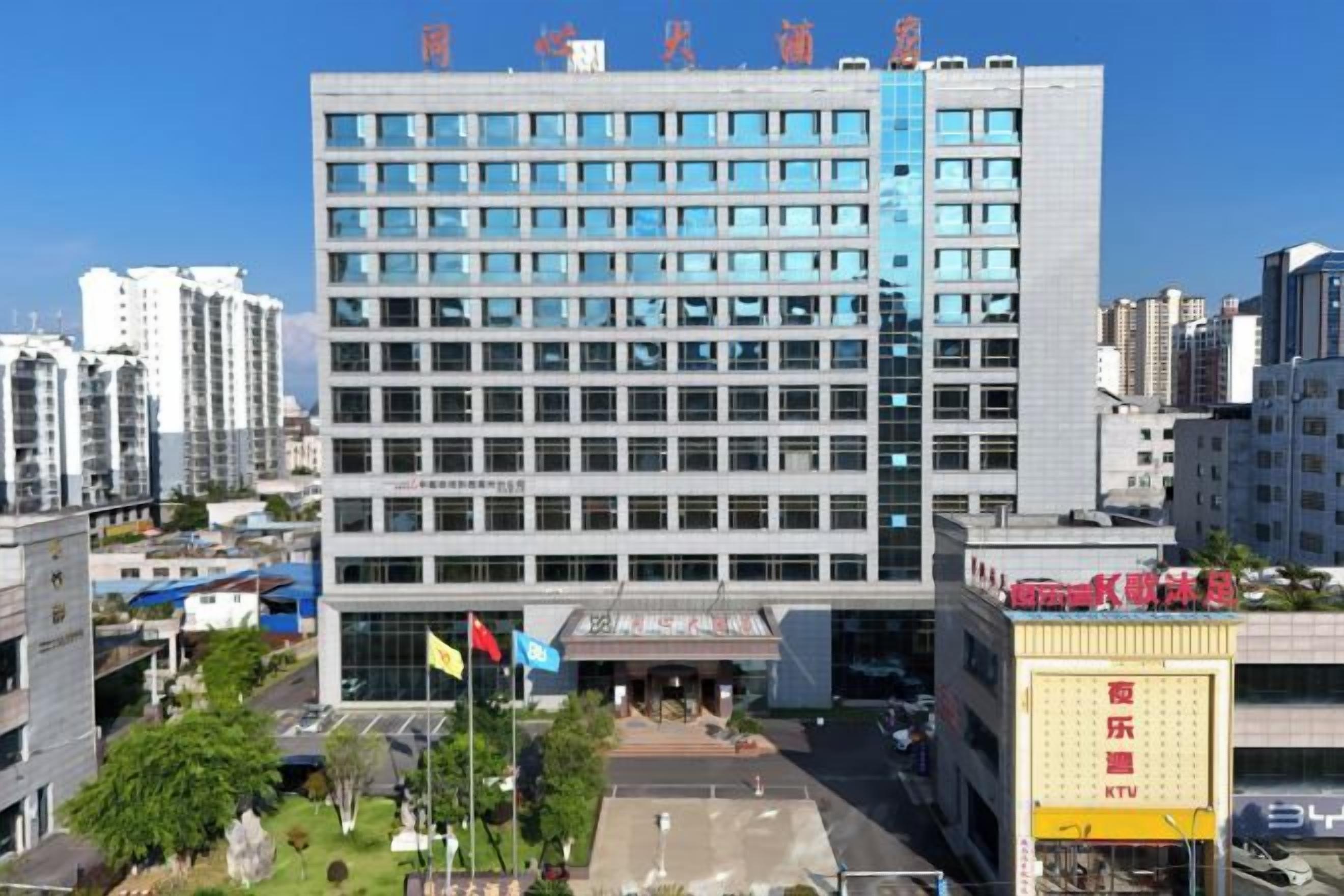 A multi-story building with a modern architectural design, featuring a flat facade and a series of windows.