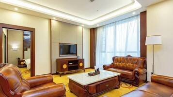 A modern living room with leather sofas, a flat-screen TV, and a coffee table.