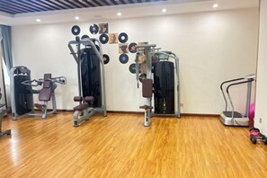 A gym with various exercise equipment, including weight machines and cardio machines. - Tongxin Hotel (Zhenfeng)