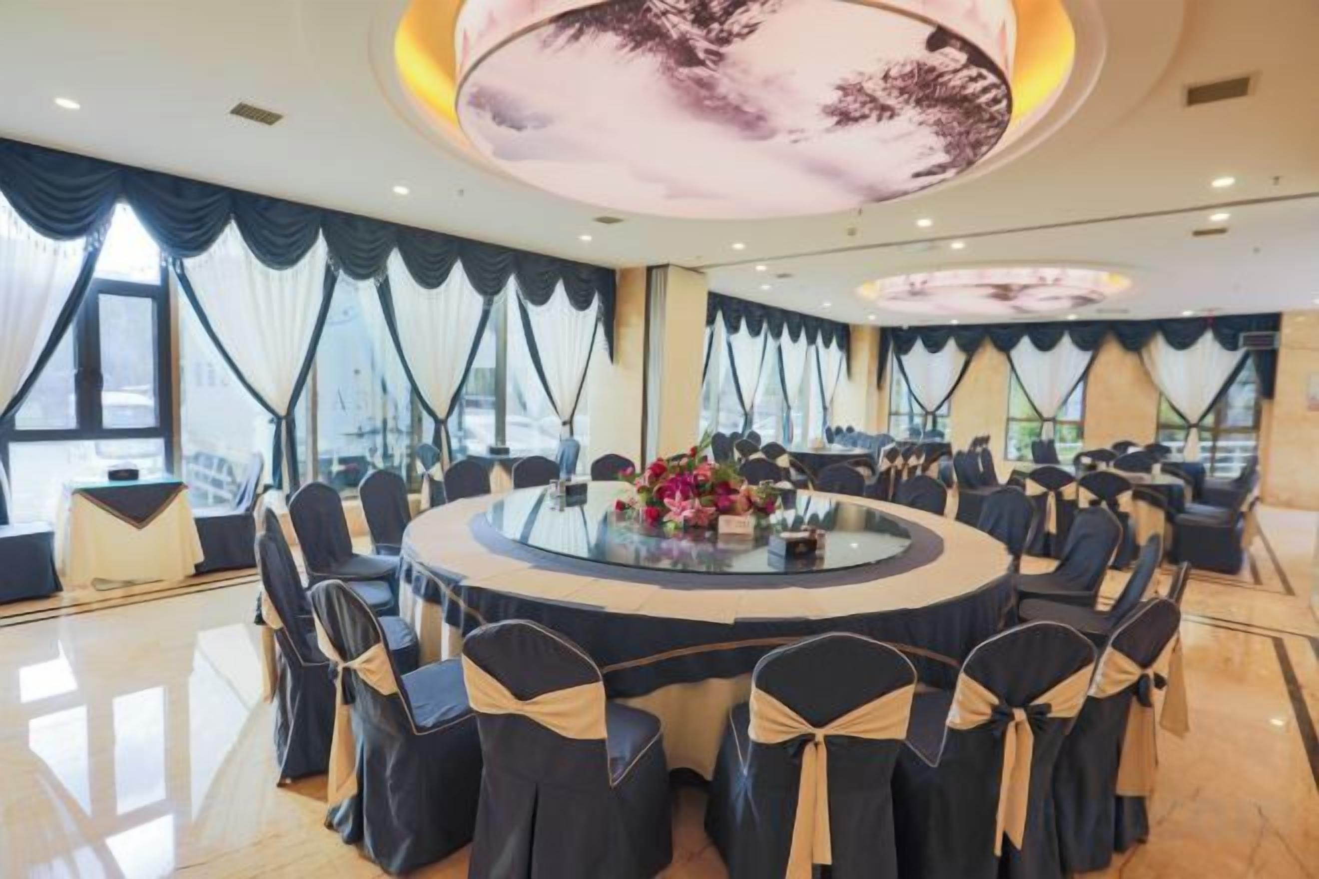 A conference room with a round table, chairs, and a large window.
