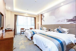 A hotel room with two beds, a desk, a chair, and a large window with curtains. - Tongxin Hotel (Zhenfeng)