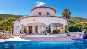 Une maison à deux étages avec une piscine à l’avant.