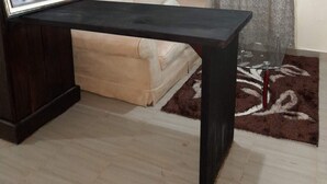 Un soggiorno con un tavolino da caffè in legno scuro, un divano beige e un tappeto decorato.