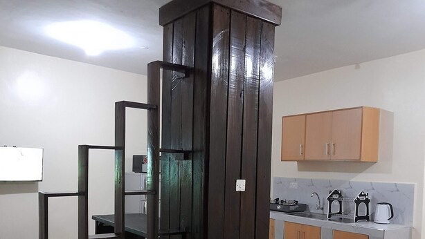 Una stanza compatta con un letto, angolo cottura e bagno.