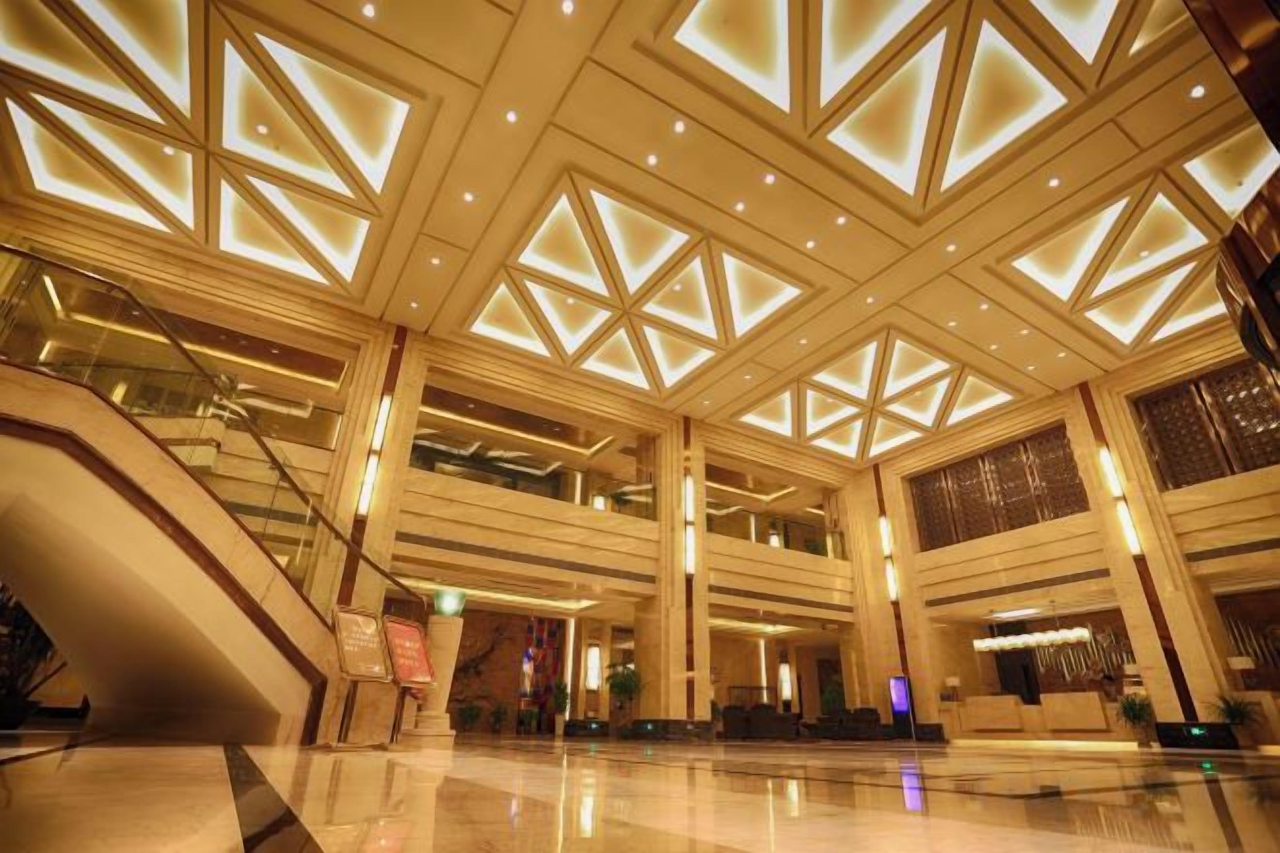 A spacious lobby with a high ceiling, multiple levels, and a central staircase.