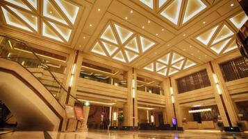 A spacious lobby with a high ceiling, multiple levels, and a central staircase.