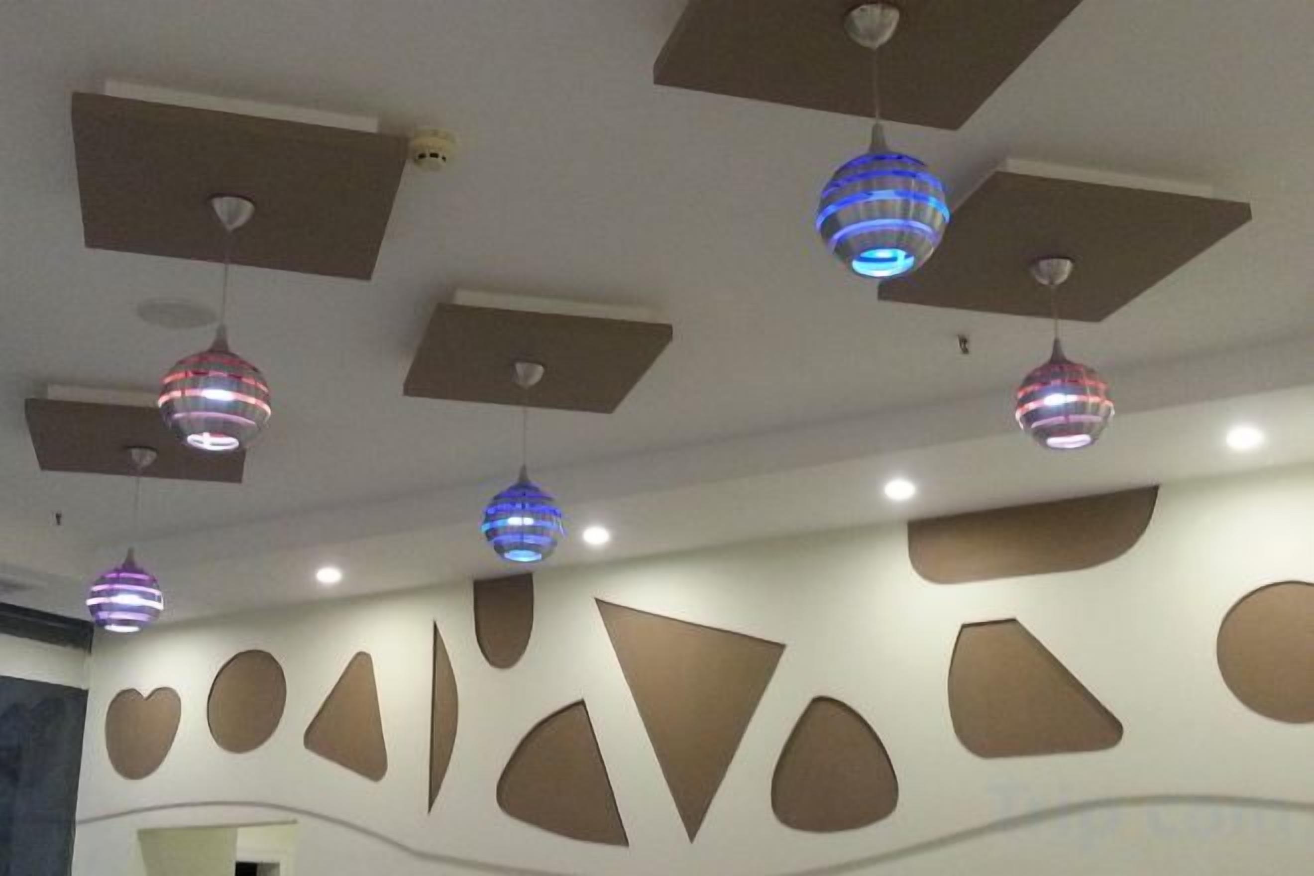 Un techo con iluminación empotrada y lámparas decorativas colgantes.