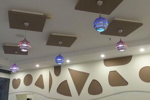 Un techo con iluminación empotrada y lámparas decorativas colgantes.