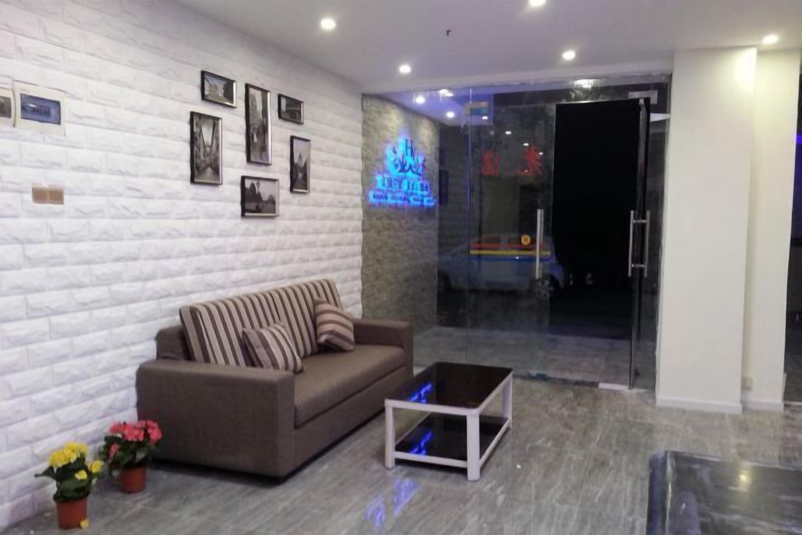 Una sala de estar moderna con un sofá, una mesita de centro y un ventanal de vidrio que da a un balcón.