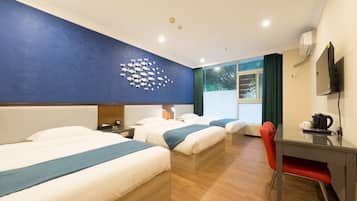 Una habitación de hotel con dos camas, un escritorio, una silla y un mural en la pared.