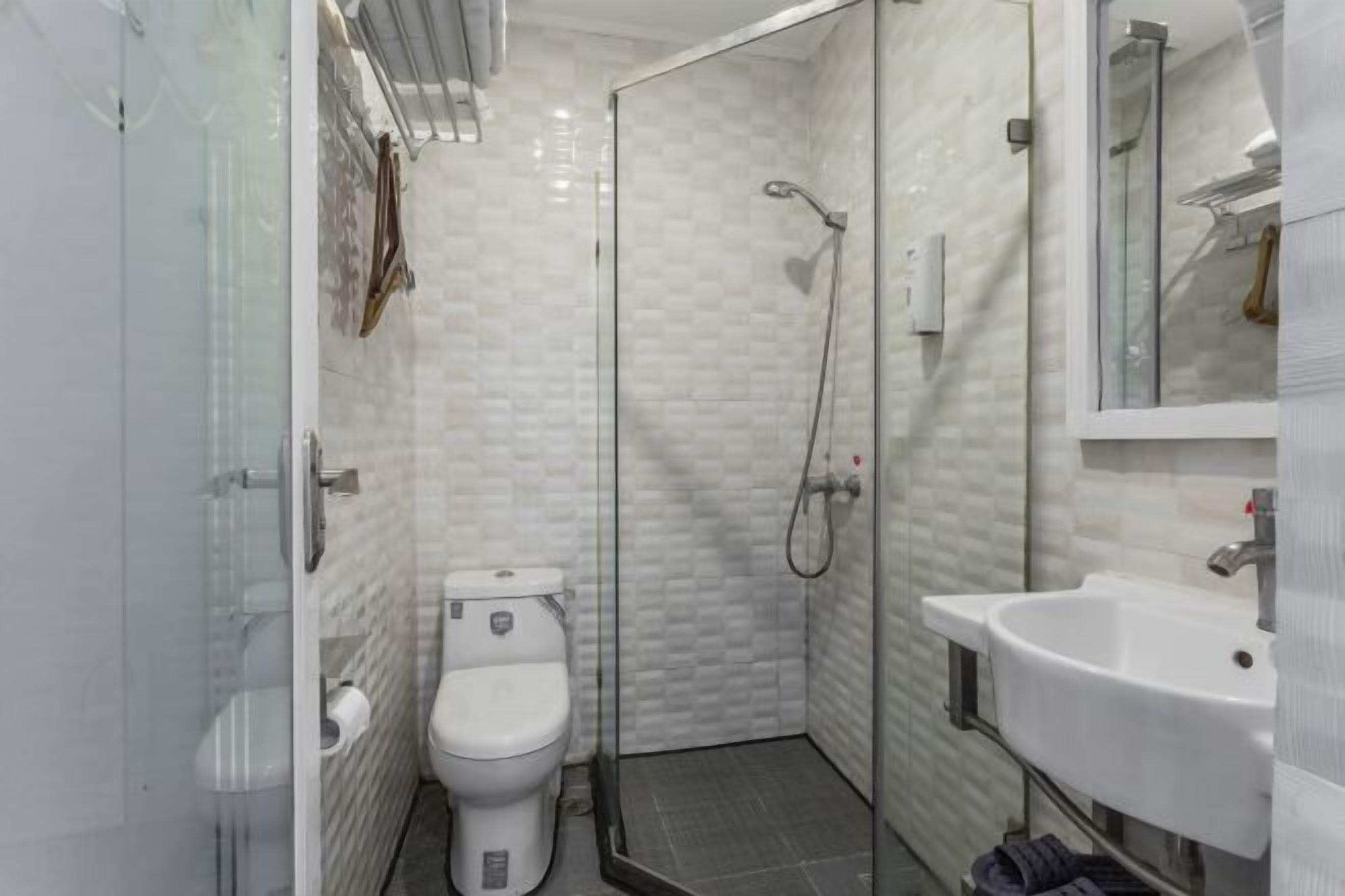 Un baño pequeño con inodoro, ducha envuelta en vidrio y lavamanos.