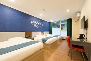 Habitación de hotel con dos camas, un escritorio, una silla y un mural de peces en la pared.