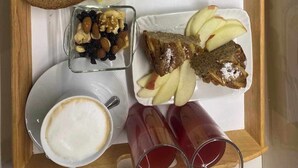 Ett bricka med frukosttillbehör, inklusive ägg, skinka, ost, bröd och en kopp kaffe.