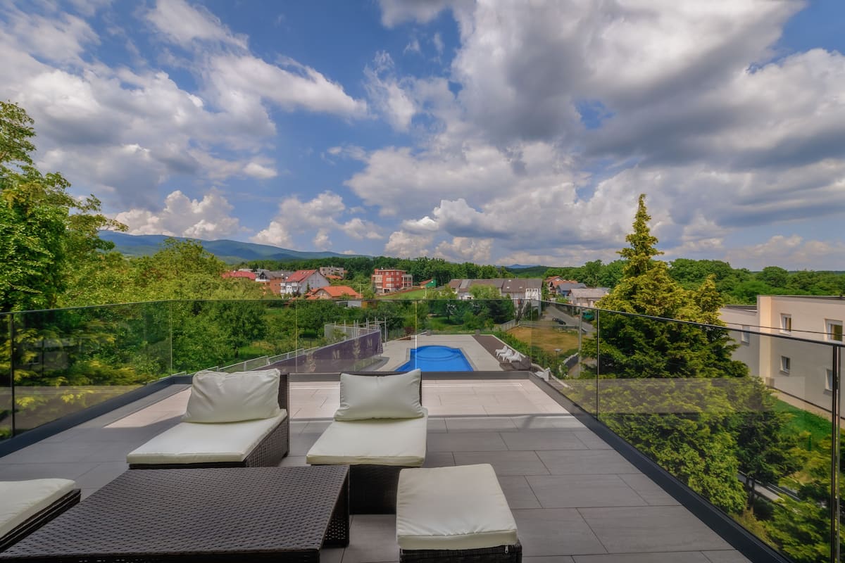 A rooftop terrace with lounge chairs and a swimming pool.