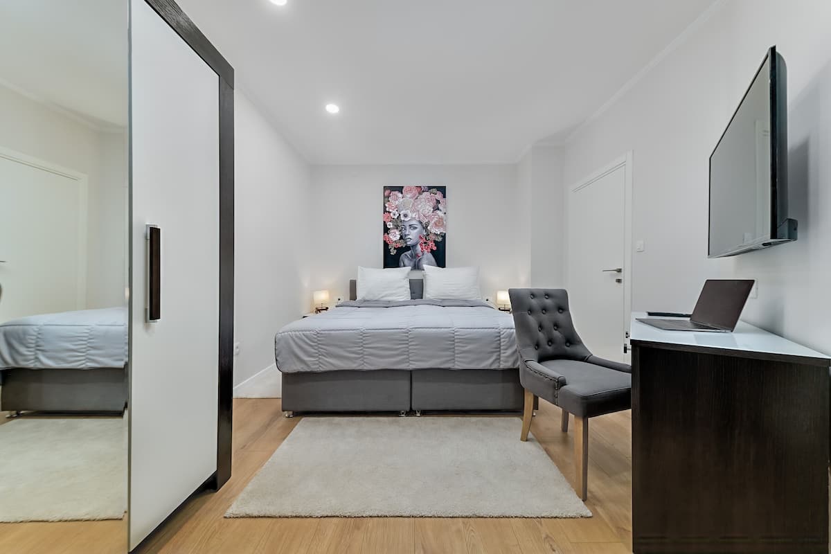 A modern bedroom with a bed, a desk, and a chair.