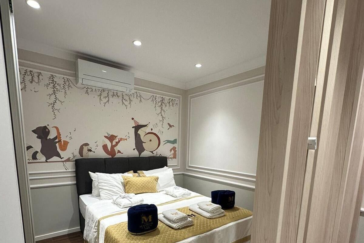 A neatly arranged bedroom with a bed, pillows, and a bedside table.