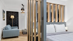 Una habitación de hotel moderna con cama, sofá, escritorio y armario.