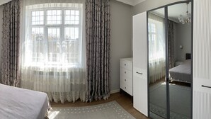Une chambre à coucher comprenant un lit, une table de chevet, une commode et une armoire.