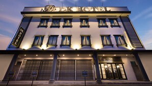 Un hotel con un letrero que dice "DK HOTEL" y varias ventanas.