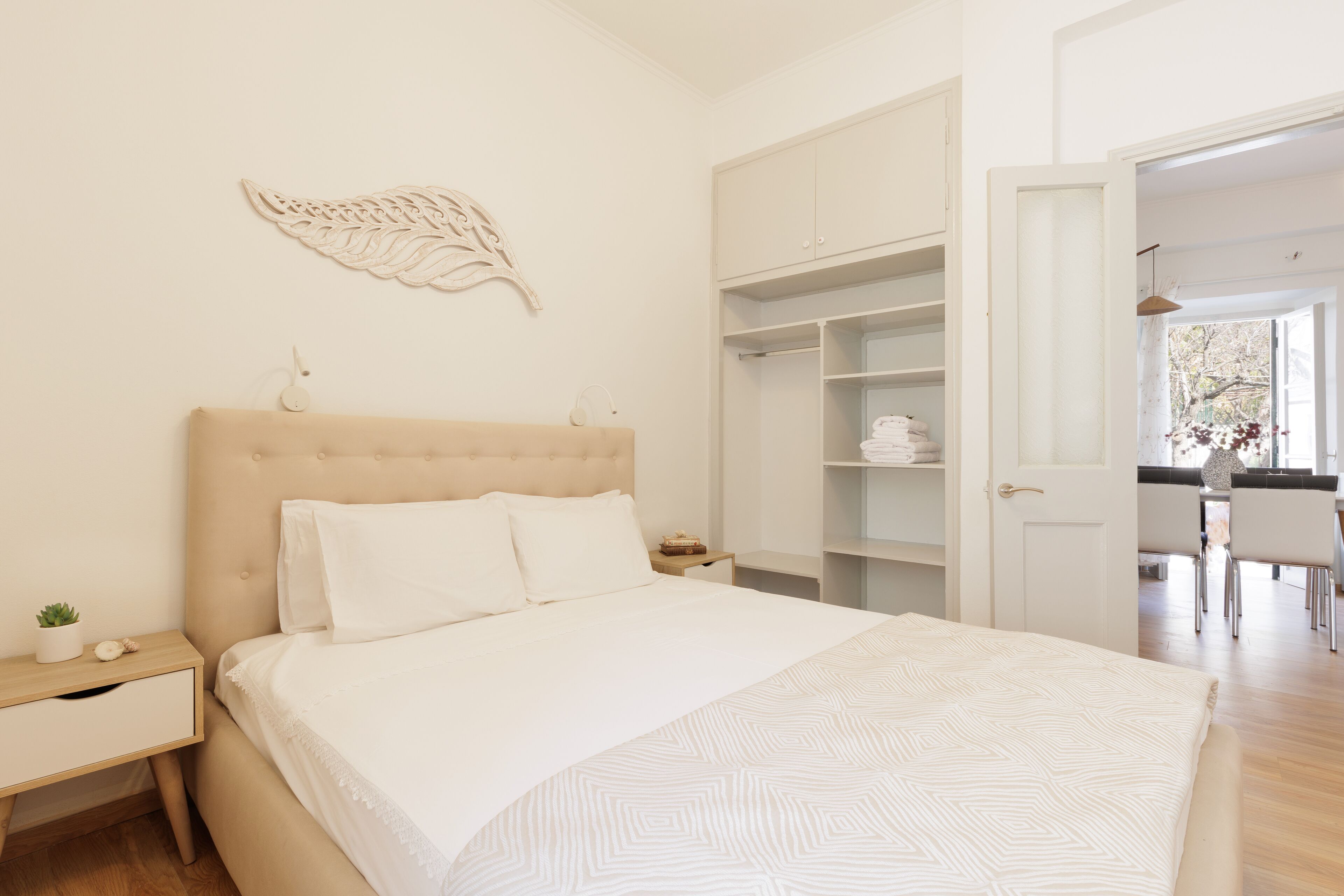 A bedroom with a bed, nightstand, and a wardrobe.