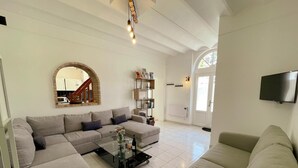 Ein modernes Wohnzimmer mit einer Eckcouch, einem Couchtisch und einem an der Wand montierten Fernseher.