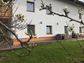 A modern building with multiple windows, a flat roof, and a well-maintained lawn. - Boskop Apartment - Schusterbrand Apartments (Absam)