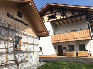 Un bâtiment à la façade en bois, doté d’un balcon et d’une enseigne sur laquelle on peut lire « Schusterbrand ».