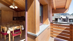 Un interior de madera con una mesa de comedor, sillas y una zona de cocina.