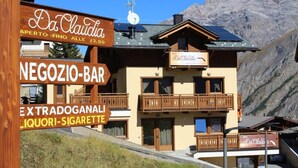 Un chalet de montagne appelé «Da Claudio», doté d’un bar, de balcons et offrant une vue sur les montagnes.