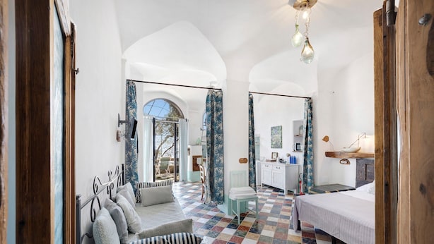 A bedroom with a checkered floor, a bed, a sofa, a desk, and a view of the outside. - 'Lavanda' Apartment with Sea View, Garden, and Wi-Fi (Finale Ligure)