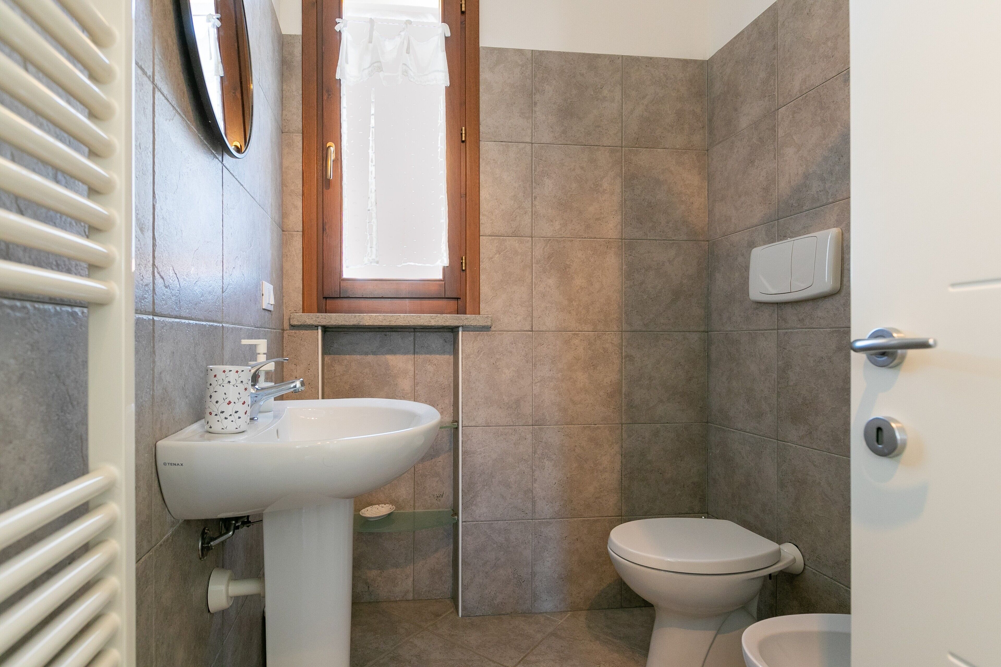 Un baño con lavamanos blanco, inodoro y zona de ducha.