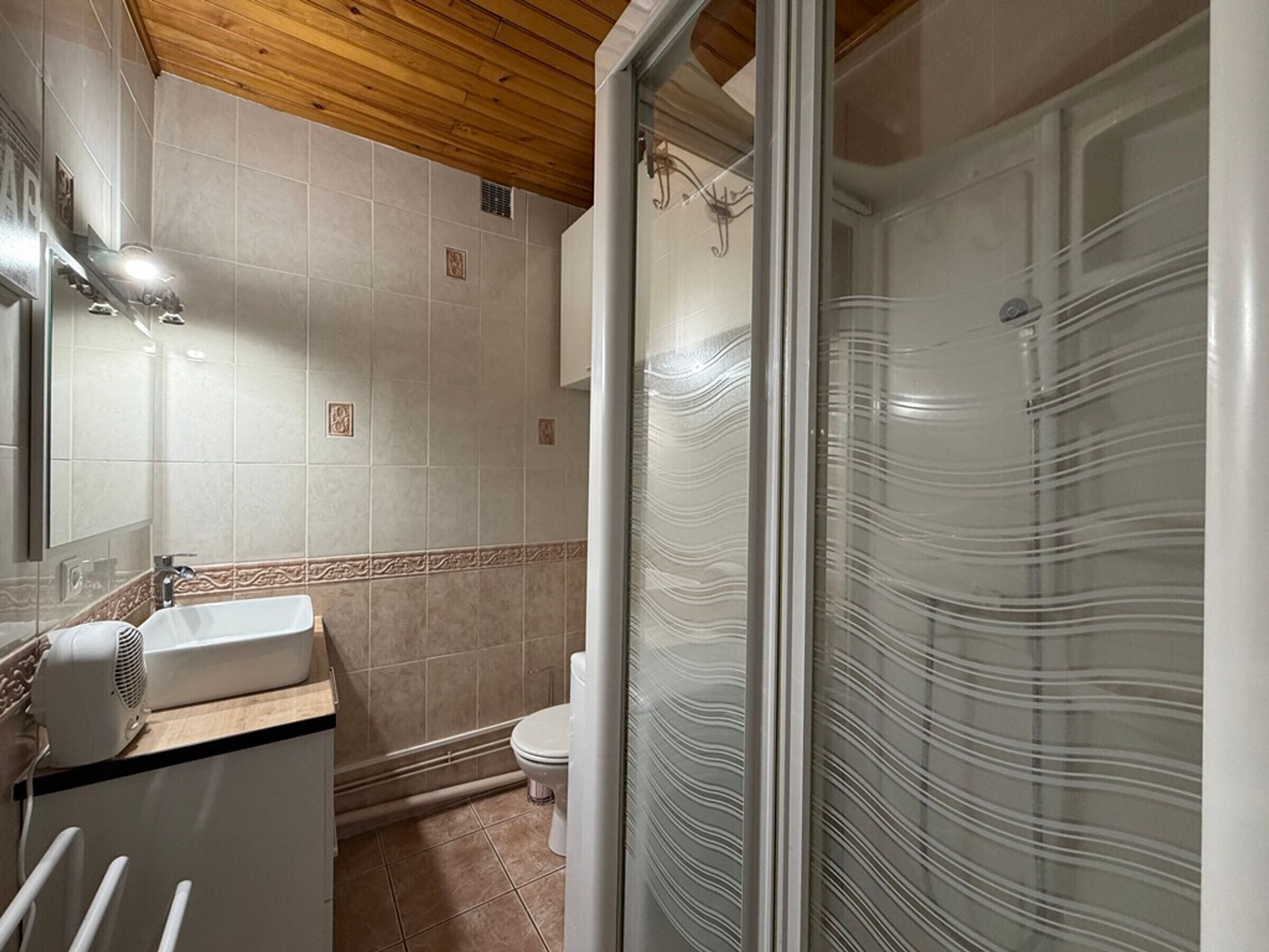 A bathroom with a sink, toilet, and shower area.