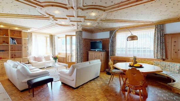 A spacious living room with a sofa set, a coffee table, and a dining area with a table and chairs. - In the heart of St. (St. Moritz)