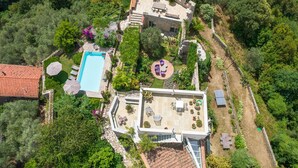 An aerial view of a villa with a swimming pool, outdoor seating area, and lush greenery. - Villa with heated pool and amazing view, Camaiore (Camaiore)