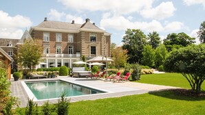 A large brick building with a swimming pool and outdoor seating area. - Maison Mairie (Hasselt)