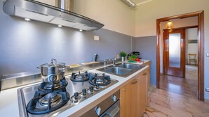 A kitchen with a stove, sink, and stainless steel cabinets. - Residenza Il Parco - Family Retreat With Garden (Ispra)
