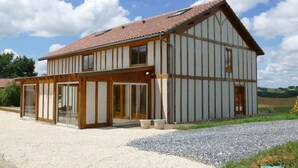 A two-story house with a sloped roof, large windows, and a gravel driveway. - Les hauts de Saint Christaud: large gite overlooking the Pyrenees (Saint-Christaud)