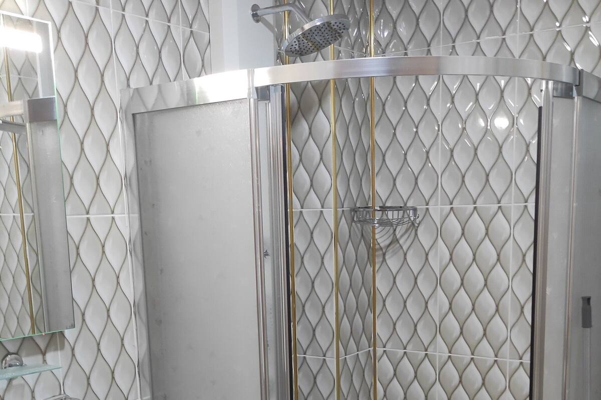 Une salle de bain avec une douche à parois de verre, un lavabo blanc et des toilettes.