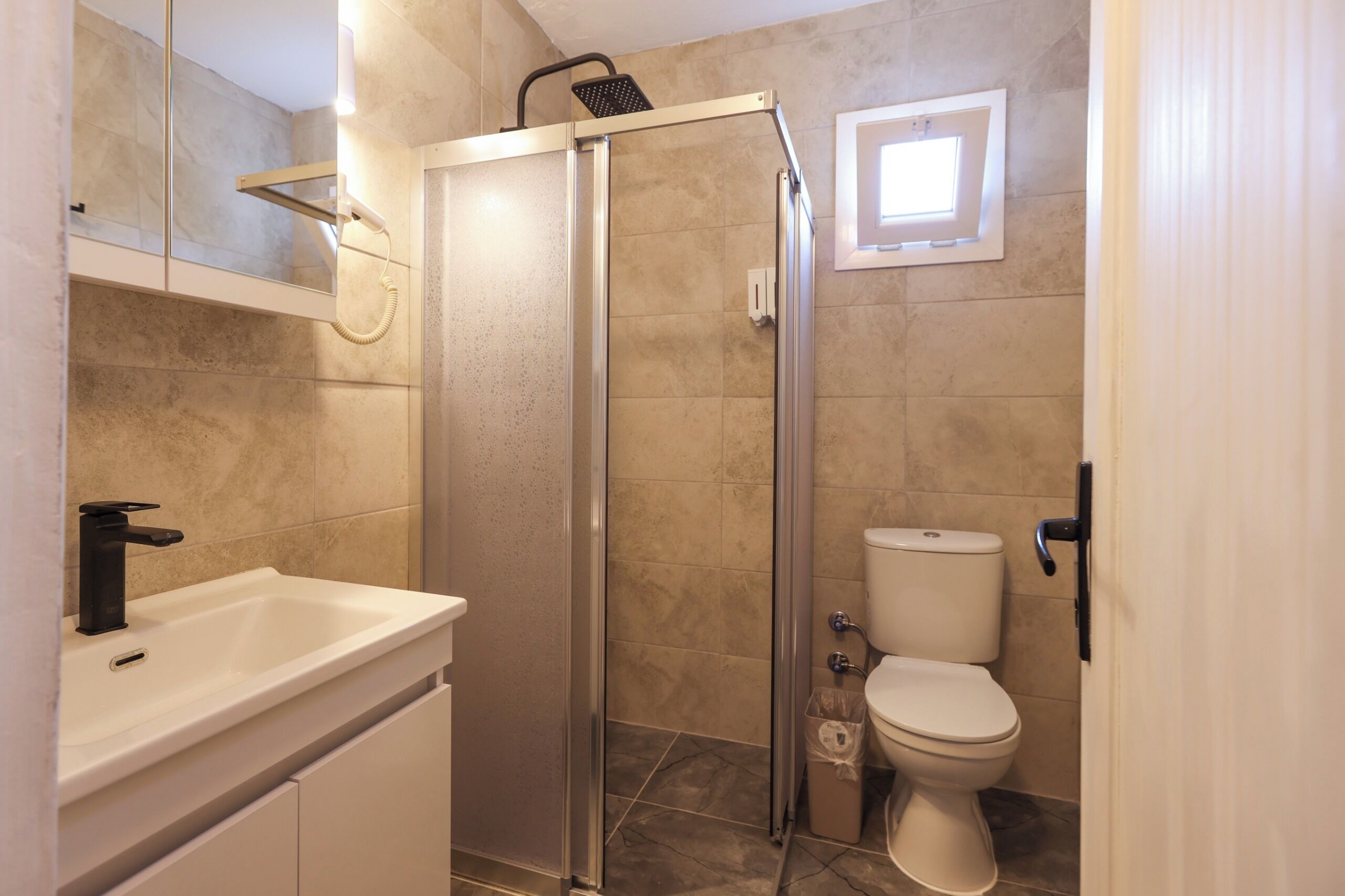 Ein Badezimmer mit Dusche, Toilette und Waschbecken.