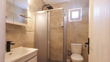Ein Badezimmer mit Dusche, Toilette und Waschbecken.